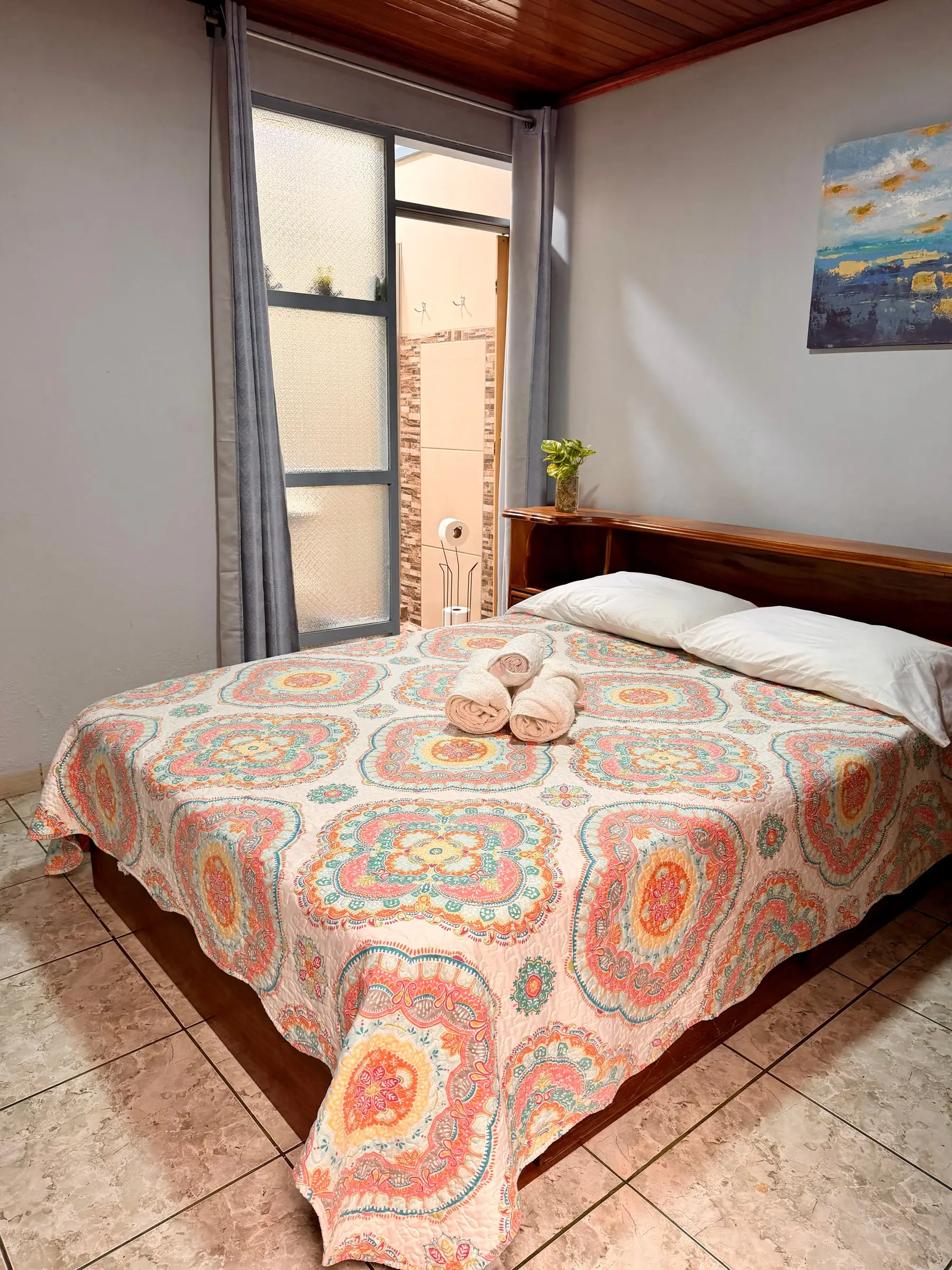 Habitación Oasis #1, interior y silenciosa, con cama queen y cabecera de madera en Casa Oasis, Alajuela