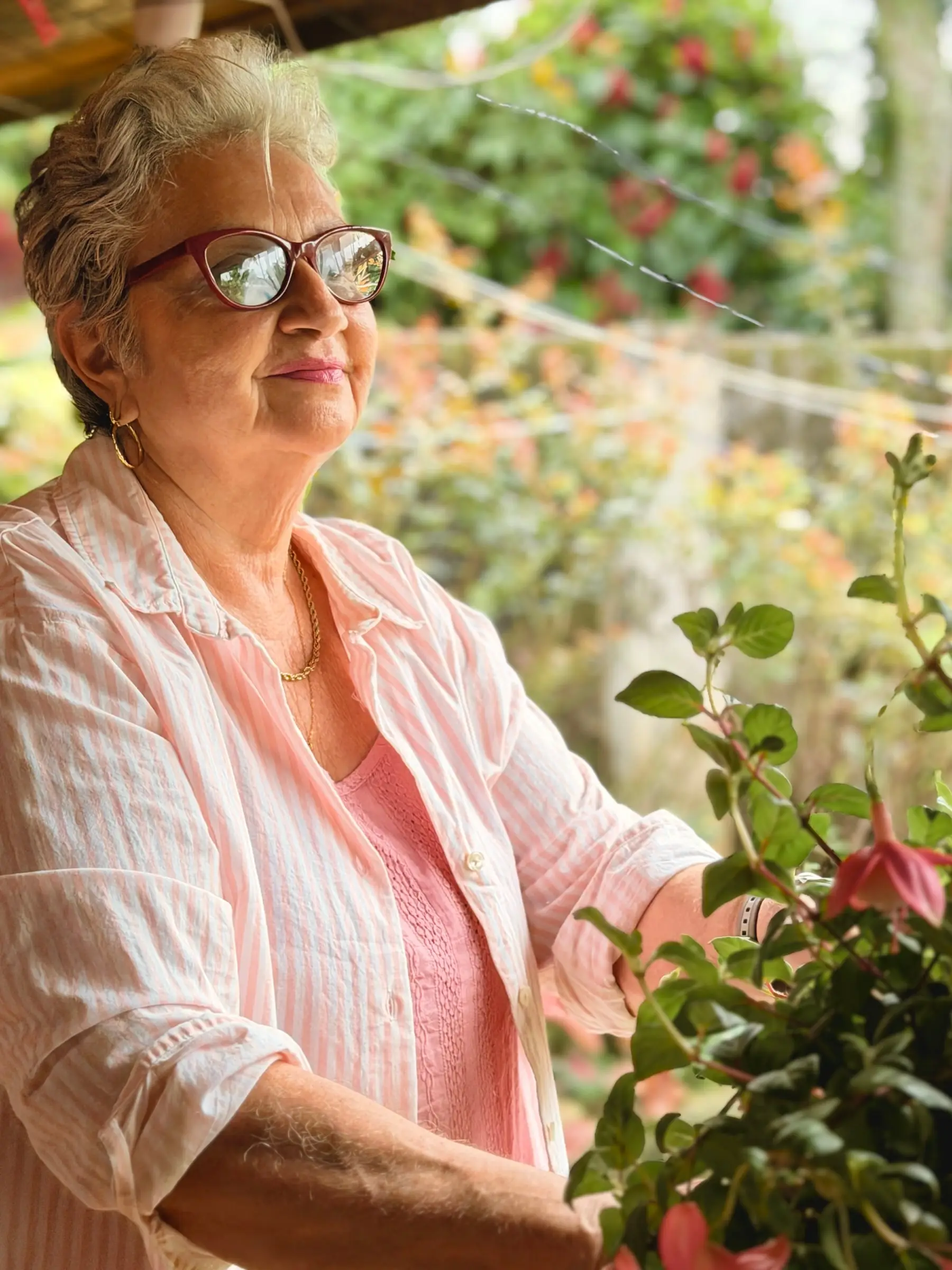 Carmen, la anfitriona de Casa Oasis, sonríe junto a sus plantas