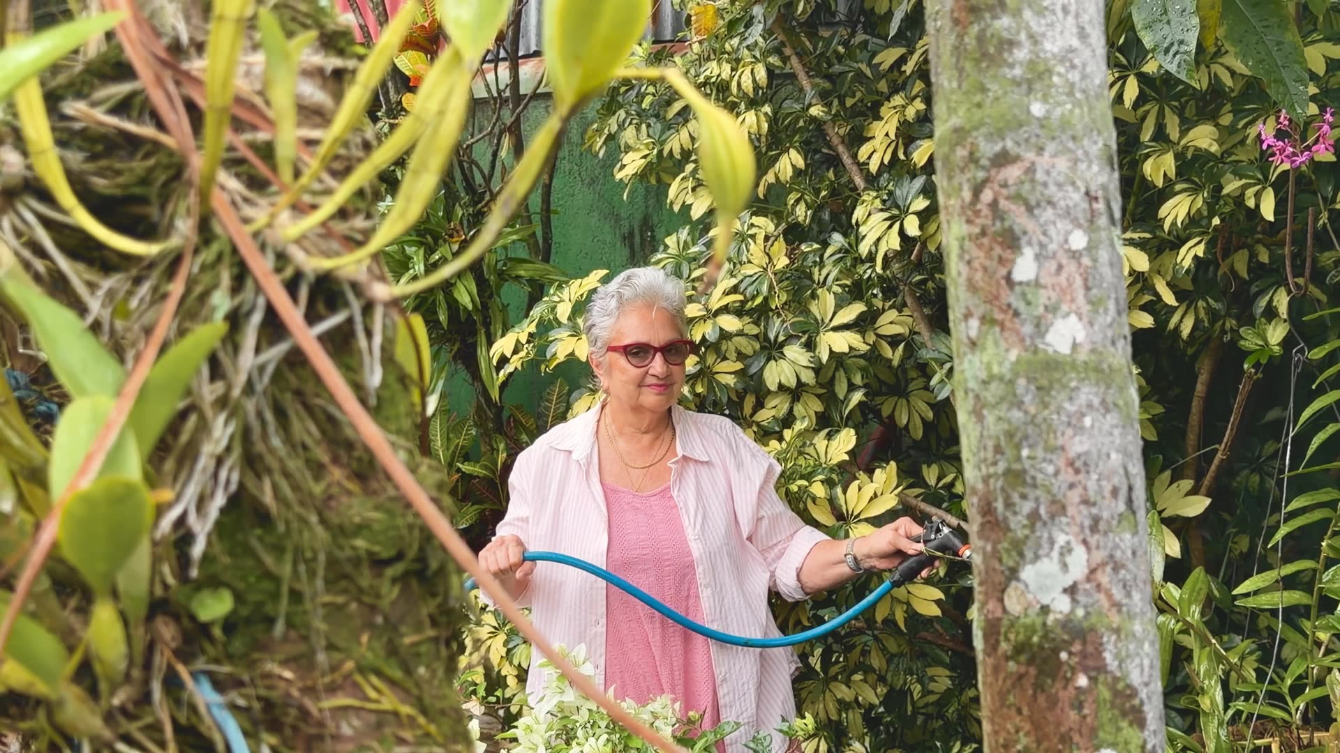 Doña Carmen riega el jardín de Casa Oasis